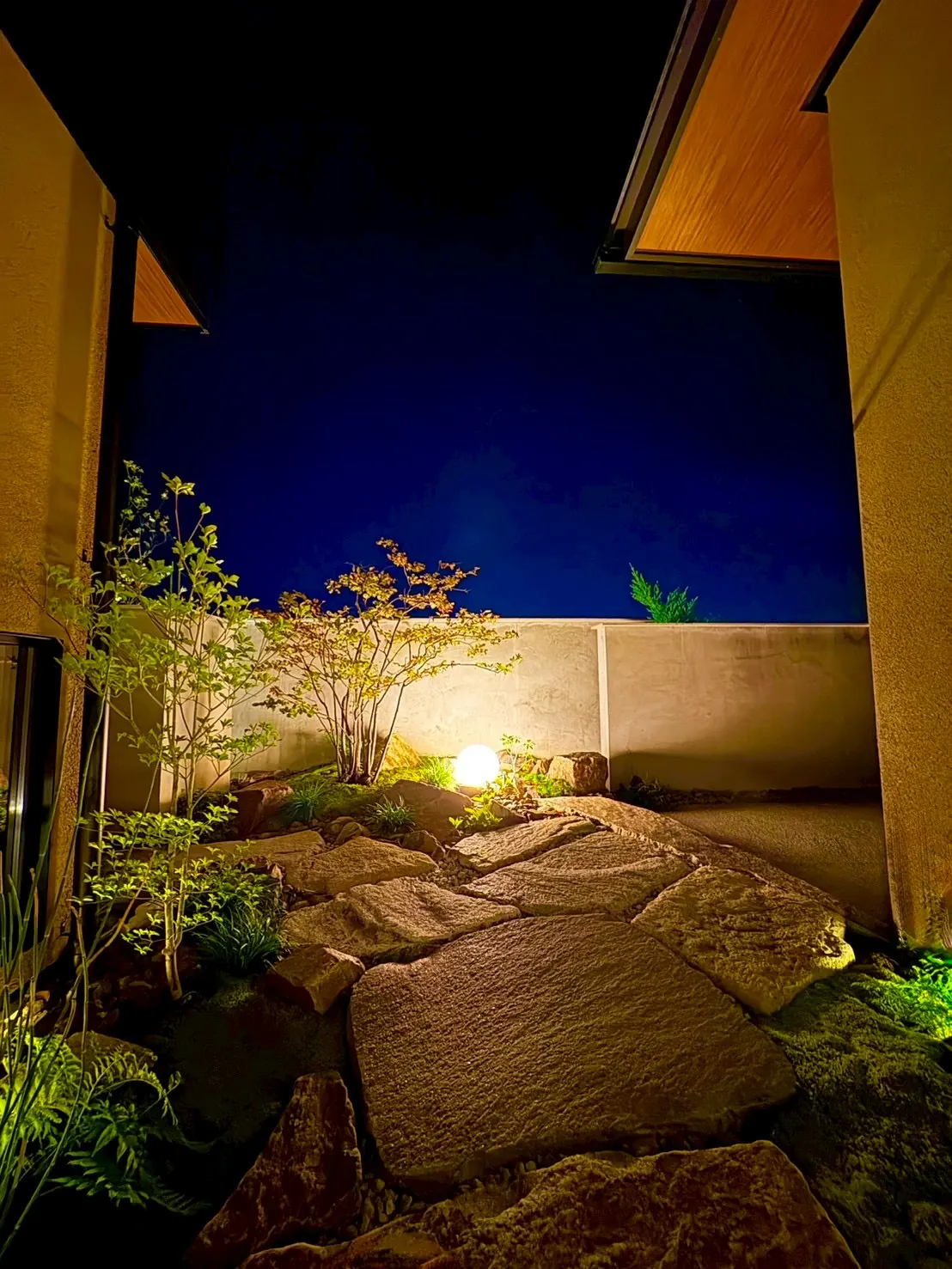 石畳の小径を球体の灯りが照らす夜の庭